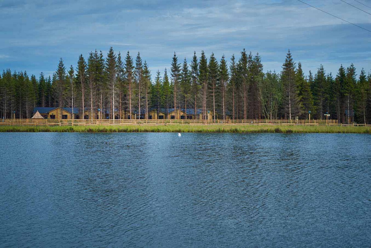 View of lake with forest and lodges in the distance