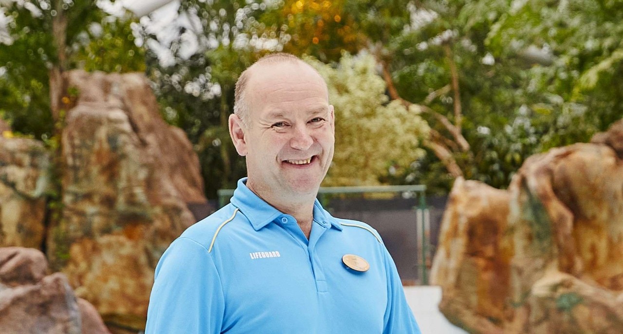 Life guard standing in Subtropical Swimming Paradise holding a recuse float