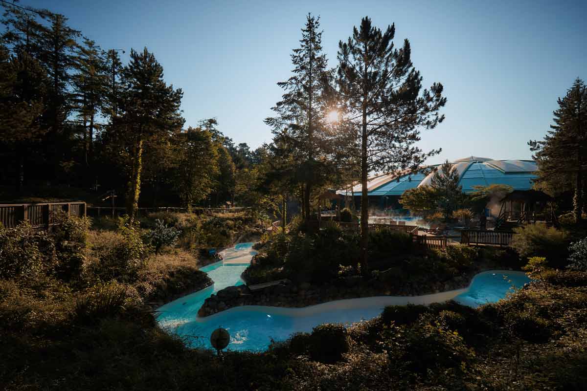 Exterior image of rapids at Longleat Forest, with sun shining through the trees