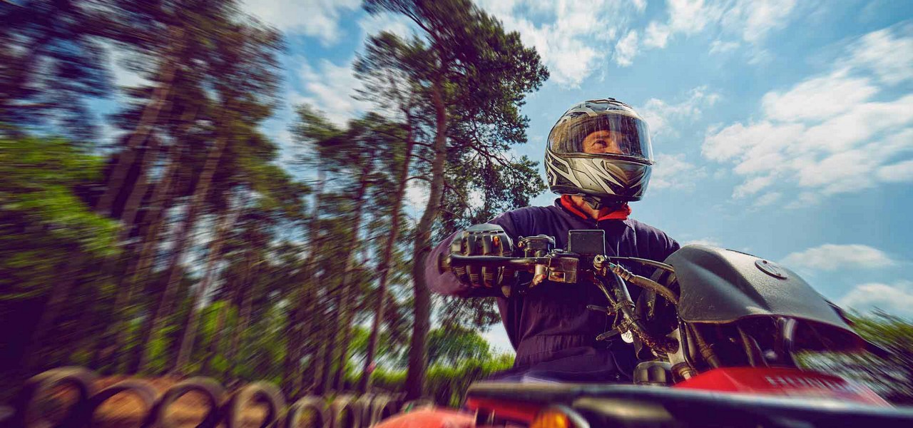 Guest on a quad bike wearing overalls and helmet 