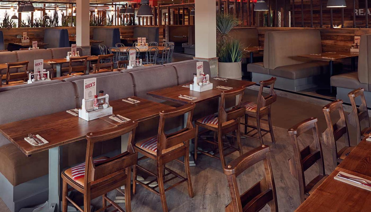 The interior of Huck's, with booths and chairs and condiments and menus on each table 