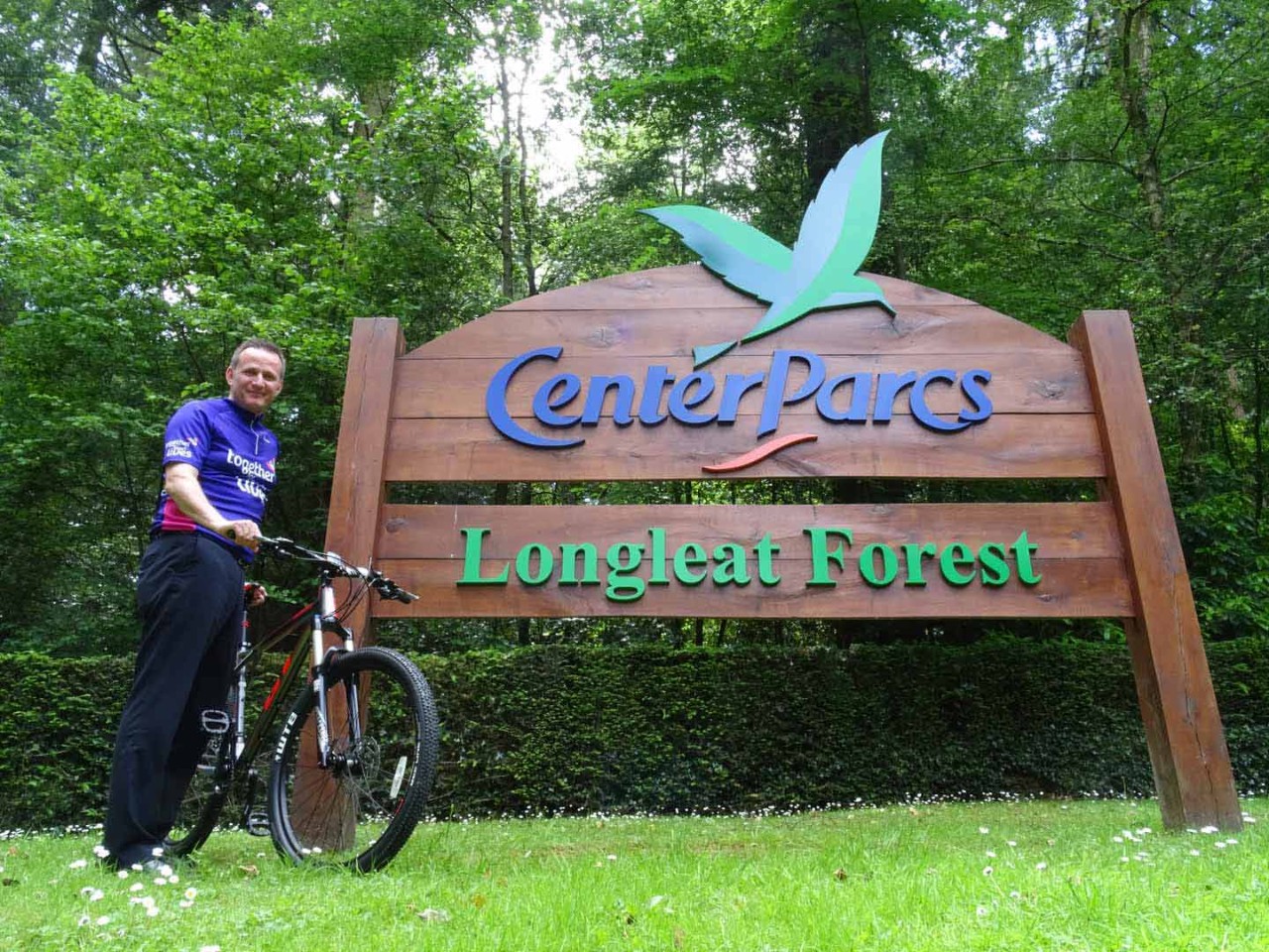 General manager of Longleat stood next to the Center Parcs welcome sign