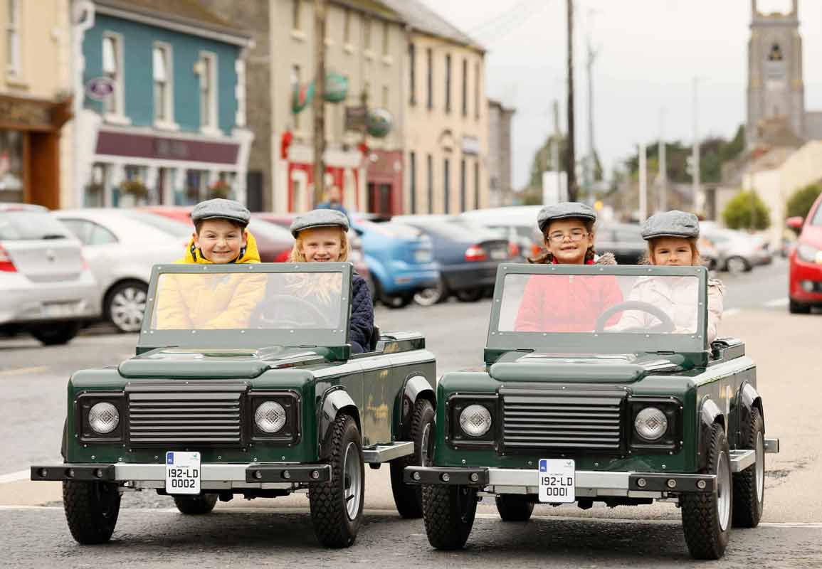 children riding in the mini explorer cars in a town