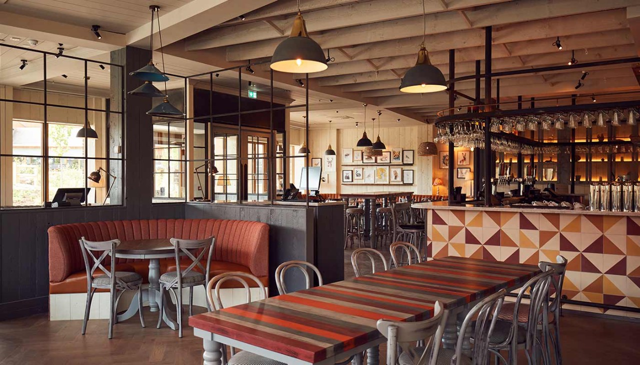 The cosy interior of Cara's Kitchen with chairs at tables and leather chaired booths
